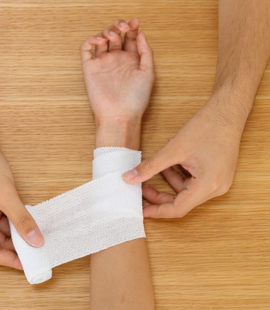 Clinician wrapping a wrist bandage during injury recovery support