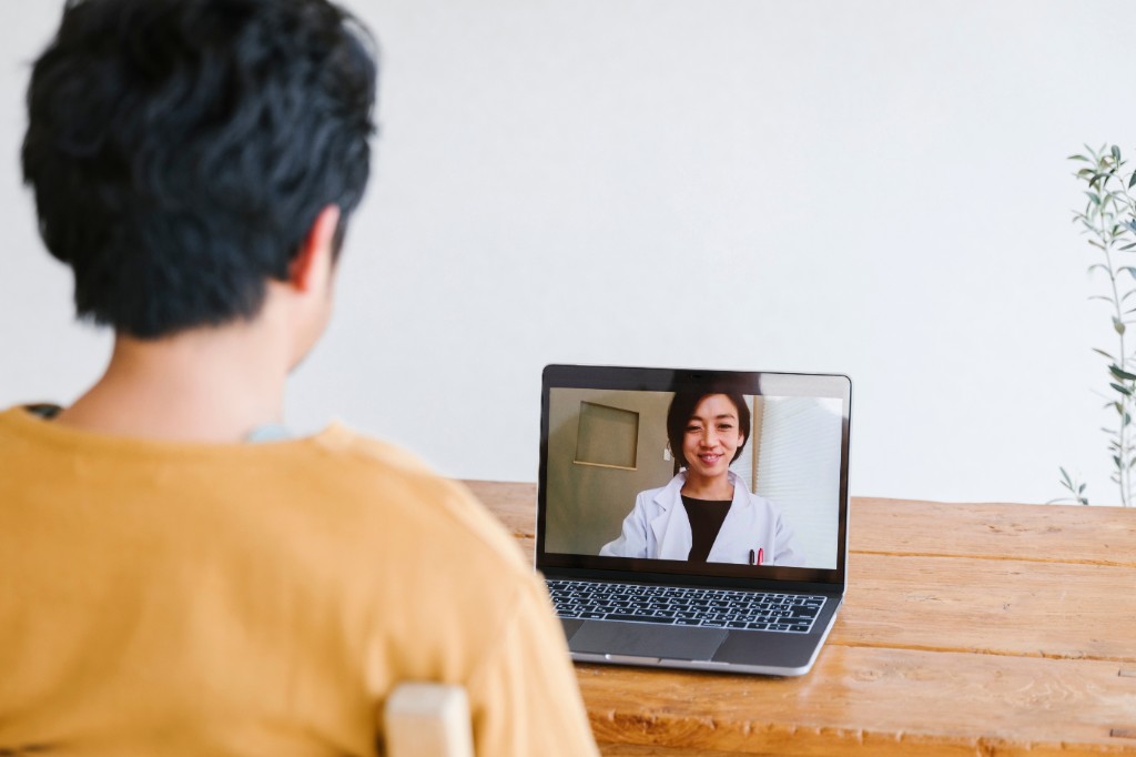 Patient in a telehealth mental health consultation on a laptop