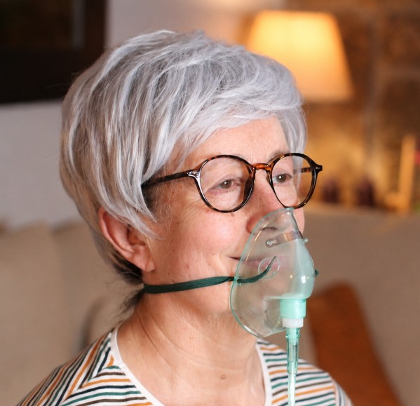 Older woman wearing an oxygen mask during respiratory care at home